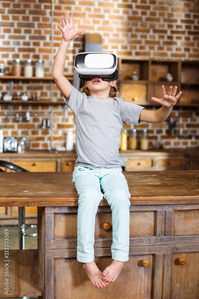 Full length of cheerful little boy wearing VR glasses Full length of cheerful little boy wearing VR glasses