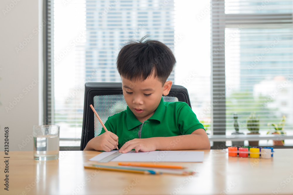 Cute boy is drawing using color pencils, isolated over white Cute boy is drawing using color pencils, isolated over white
