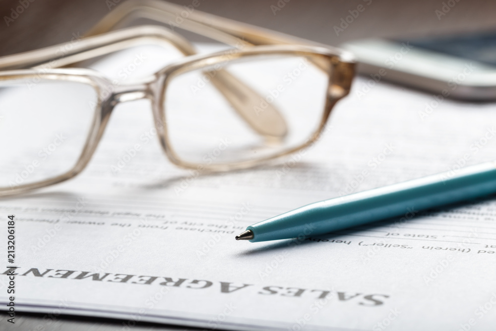 Close up shot of Eyeglasses on contract document papers business concept Close up shot of Eyeglasses on contract document papers business concept