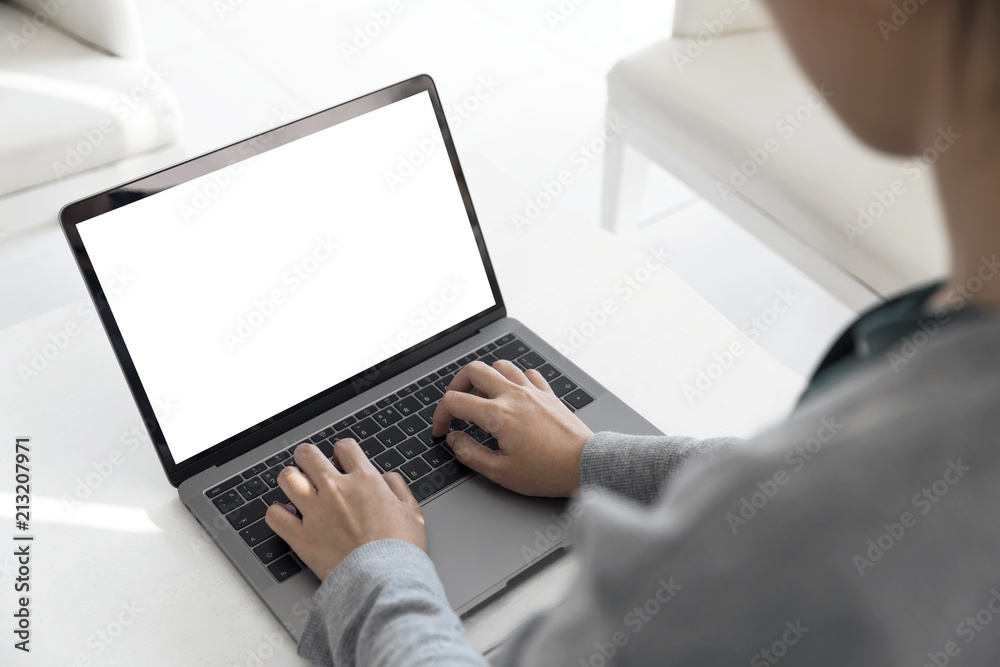 Women using laptop with blank screen at table in the office Women using laptop with blank screen at table in the office
