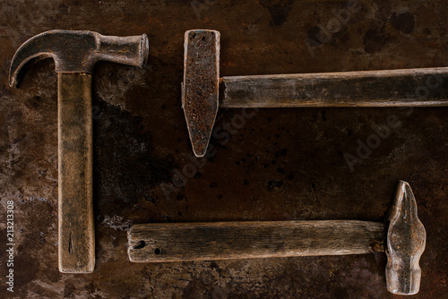 Fototapeta top view of arranged retro hammers on rusty  surface