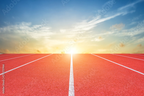 White lines of stadium and texture of running racetrack red rubber racetracks or Athlete track or running track with blue sky white cloud,sky sunset background.