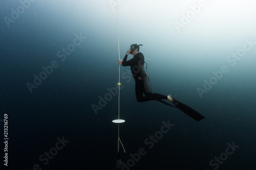 Student freediver learns presure equalization being on a depth and holding a rope photo