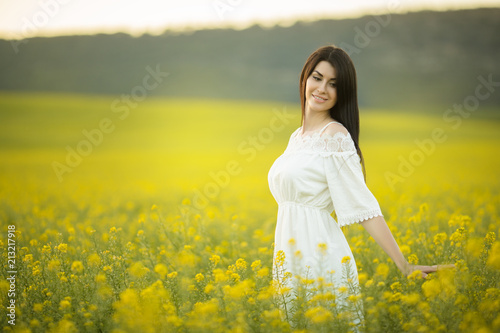 Happy young woman with bouquet of wildflowers in yellow field in sunset lights, summer time © _chupacabra_