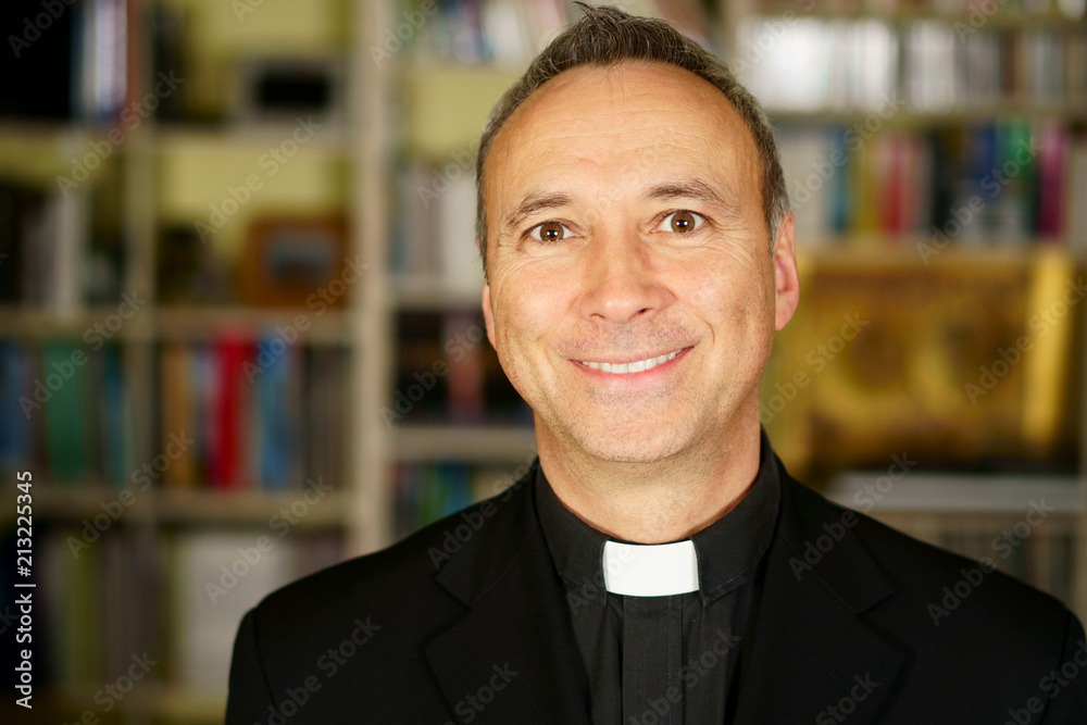 A portrait of a good looking smiling catholic priest. He looks at us with interest, pensiveness, proselytising, joy, happiness and peacefulness. A portrait of a good looking smiling catholic priest. He looks at us with interest, pensiveness, proselytising, joy, happiness and peacefulness.