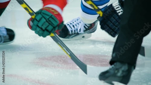 slow motion macro puck falls on ice after face-off rotating