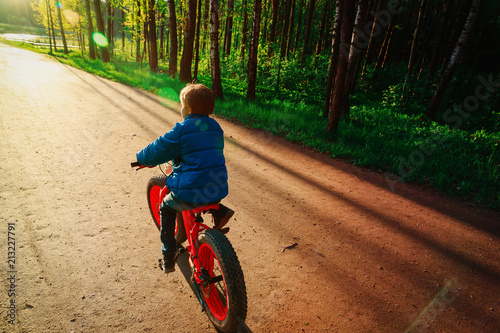 Fototapeta Naklejka Na Ścianę i Meble -  boy riding bike at sunset