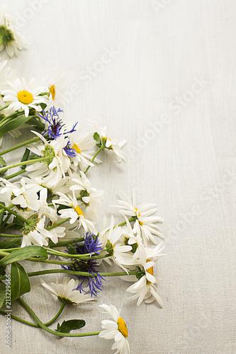 camomile   daisy and a cornflower bouquet on gray light texture dark background a postcard