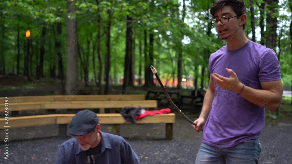 Closeup of teen boy lifting marshmallow off of a stick and putting it into his mouth. Closeup of teen boy lifting marshmallow off of a stick and putting it into his mouth.