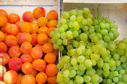 Boxes with apricots and white grapes from mediterranean farmers market. Healthy local organic food summer market.