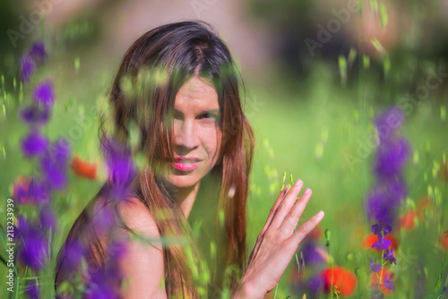 Beautiful Spring Young Woman Outdoors Enjoying Nature. Healthy Smiling Girl in flower Spring Meadow