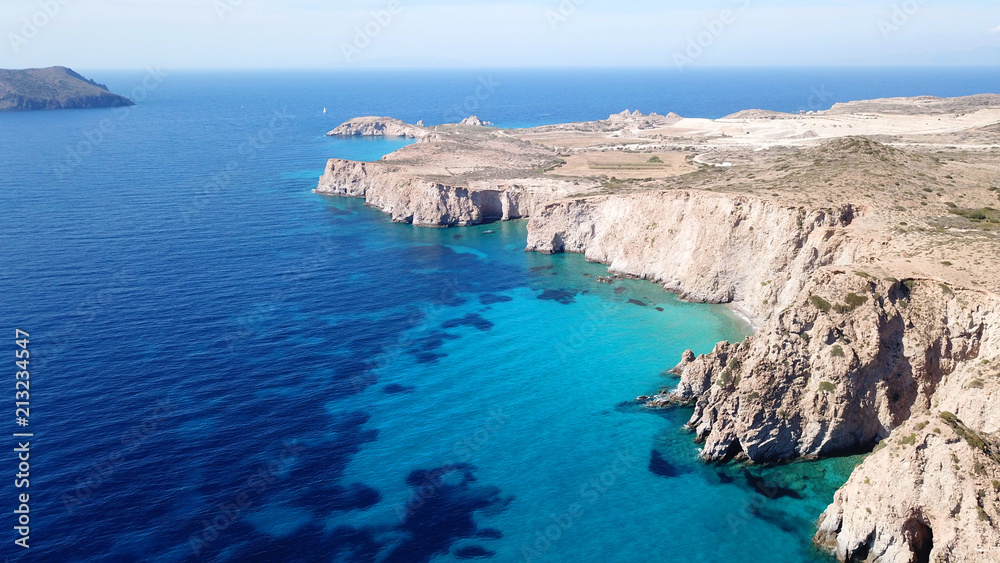 Aerial drone bird's eye view of volcanic and exotic rocky beach with turquoise and sapphire clear waters of Plathiena in island of Milos, Cyclades, Greece