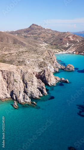 Aerial drone bird's eye view of volcanic and exotic rocky beach with turquoise and sapphire clear waters of Plathiena in island of Milos, Cyclades, Greece