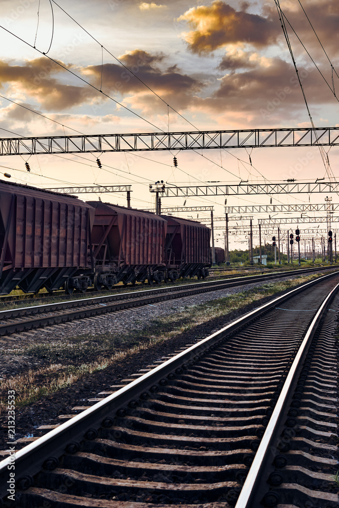 railroad infrastructure during beautiful sunset and colorful sky, railcar for dry cargo, transportation and industrial concept railroad infrastructure during beautiful sunset and colorful sky, railcar for dry cargo, transportation and industrial concept