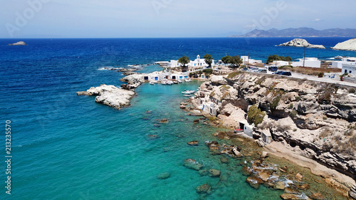 Aerial drone bird's eye view photo of picturesque small fishing harbor of Mandrakia with boat houses called syrmata and fishing boats docked on turquoise clear waters, Milos island, Cyclades, Greece