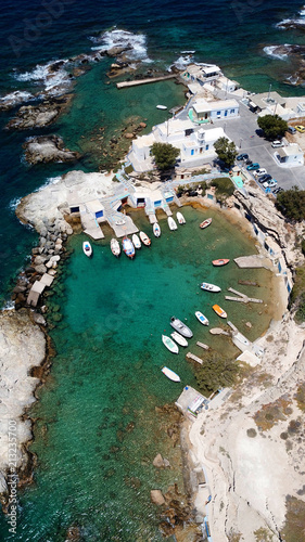 Aerial drone bird's eye view photo of picturesque small fishing harbor of Mandrakia with boat houses called syrmata and fishing boats docked on turquoise clear waters, Milos island, Cyclades, Greece photo