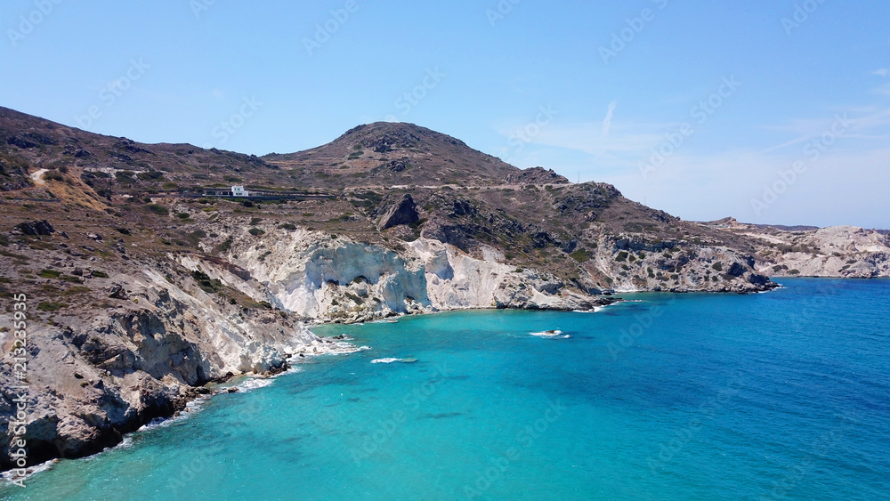 Aerial drone bird's eye view photo of picturesque small fishing harbor of Mandrakia with boat houses called syrmata and fishing boats docked on turquoise clear waters, Milos island, Cyclades, Greece