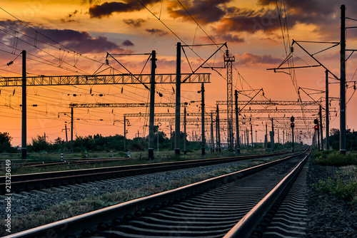 railroad infrastructure during beautiful sunset and colorful sky, railcar and traffic lights, transportation and industrial concept