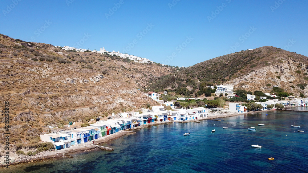 Aerial drone bird's eye view photo of picturesque and colourful fishing village of Klima with traditional character and uphill village of Plaka at the background, Milos island, Cyclades, Greece