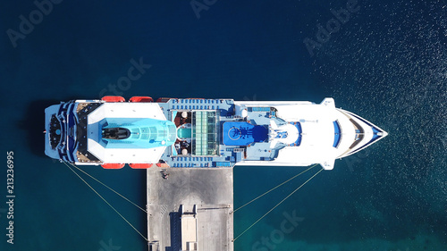 Aerial drone bird's eye top view photo of large cruiser ship docked in deep blue water mediterranean port © aerial-drone