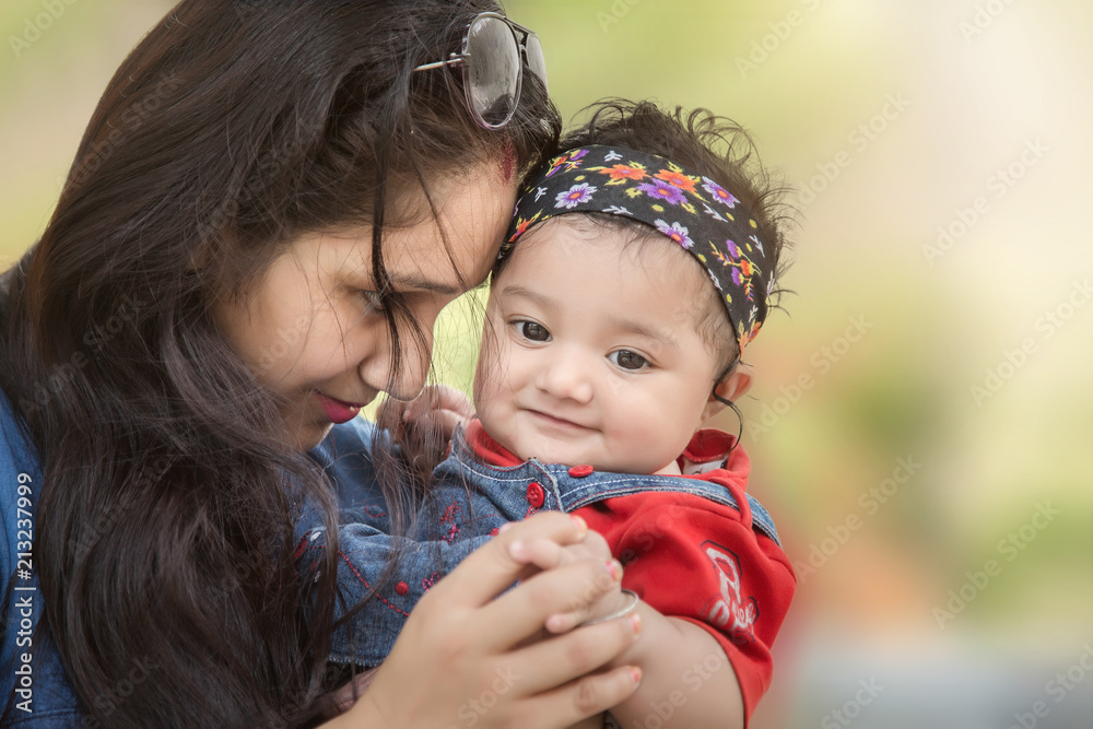 Closeup of happy mother and daughter standing in the park looking at camera. selective focus, shallow depth of field. Closeup of happy mother and daughter standing in the park looking at camera. selective focus, shallow depth of field.