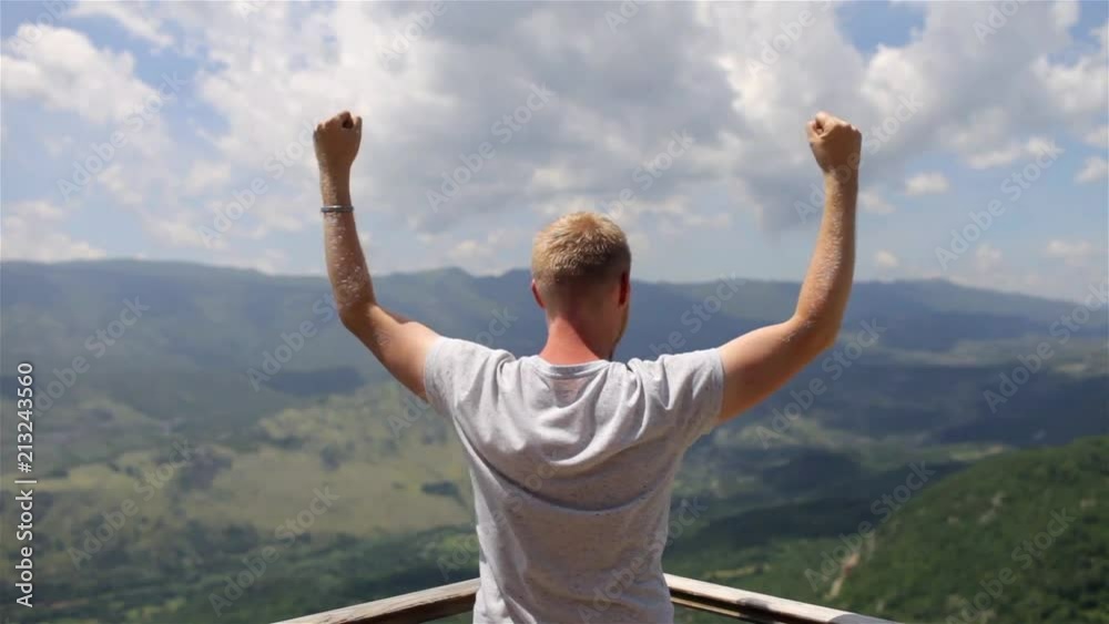 man celebrates the achievement with a view of the mountains