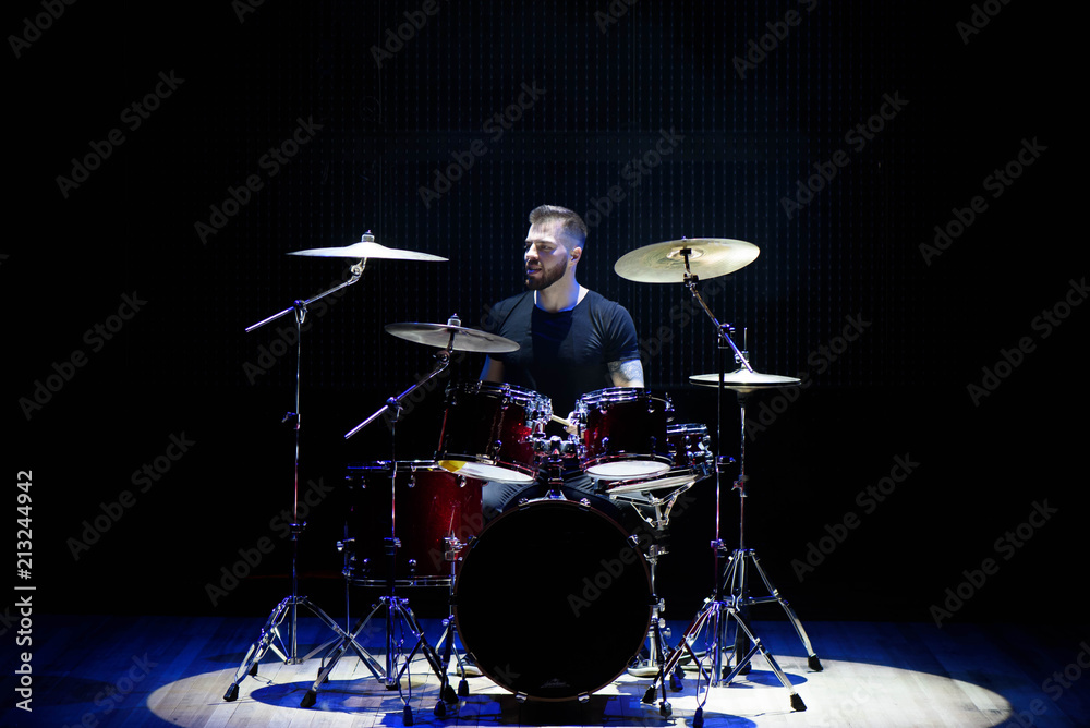 Fototapeta premium Silhouette drummer on stage. Dark background, smoke spotlights