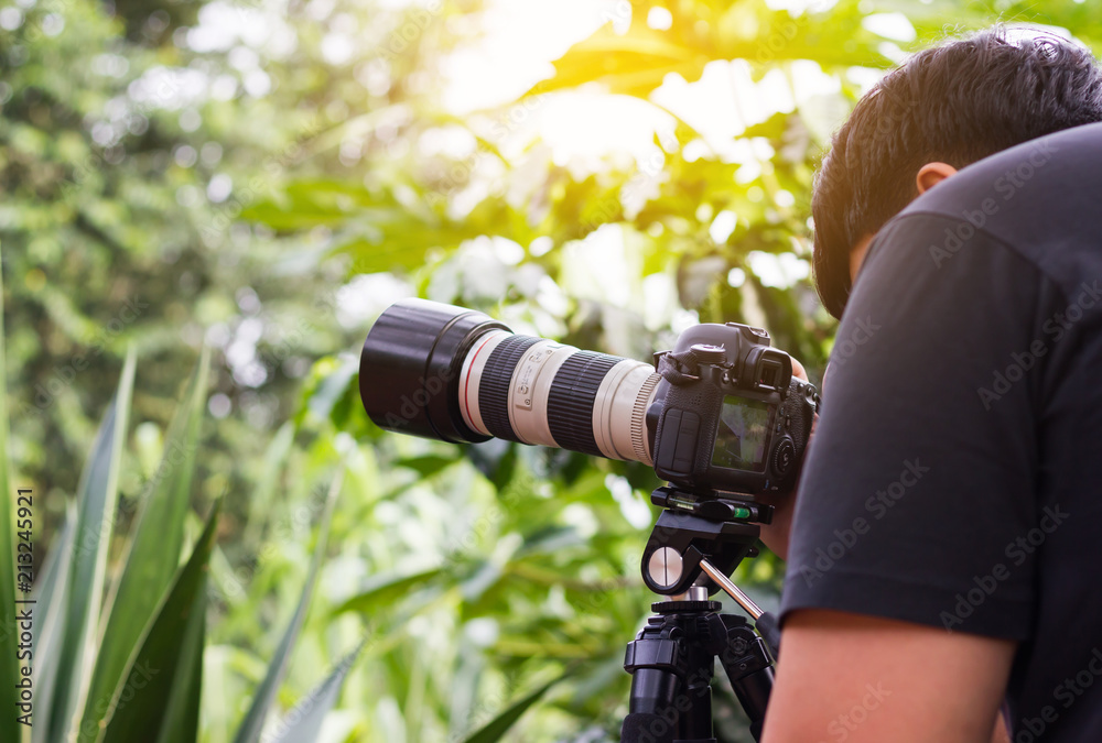 Big camera with zoom lens and a black hair men or photographer, working or  hobby ,shooting nature Stock Photo | Adobe Stock