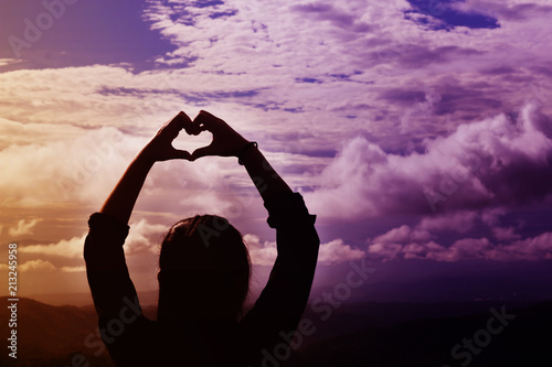 Cuadro en lienzo Back or rare view women do hand symbol of heart in fantasy dreamy violet and ora