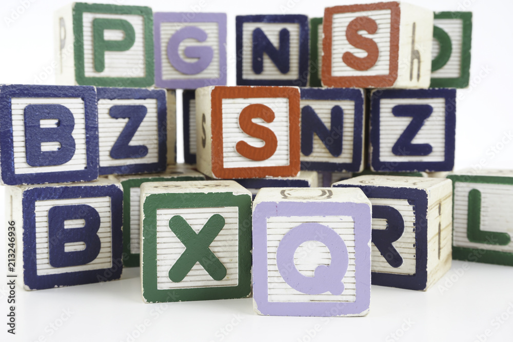 Colored wooden letter blocks on a white background with copy space Colored wooden letter blocks on a white background with copy space