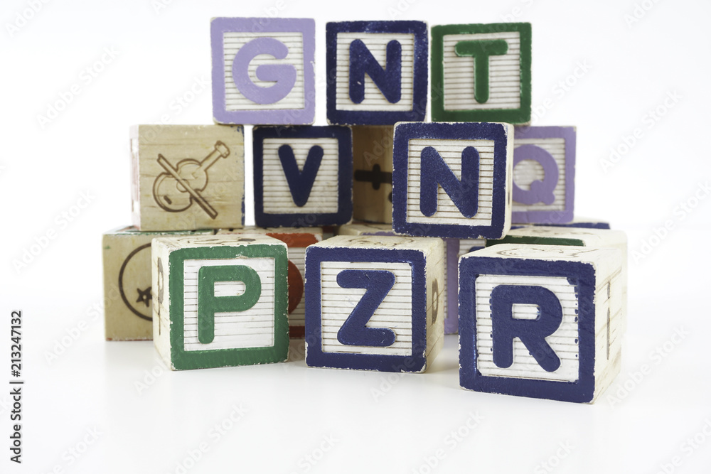 Colored wooden letter blocks on a white background with copy space Colored wooden letter blocks on a white background with copy space