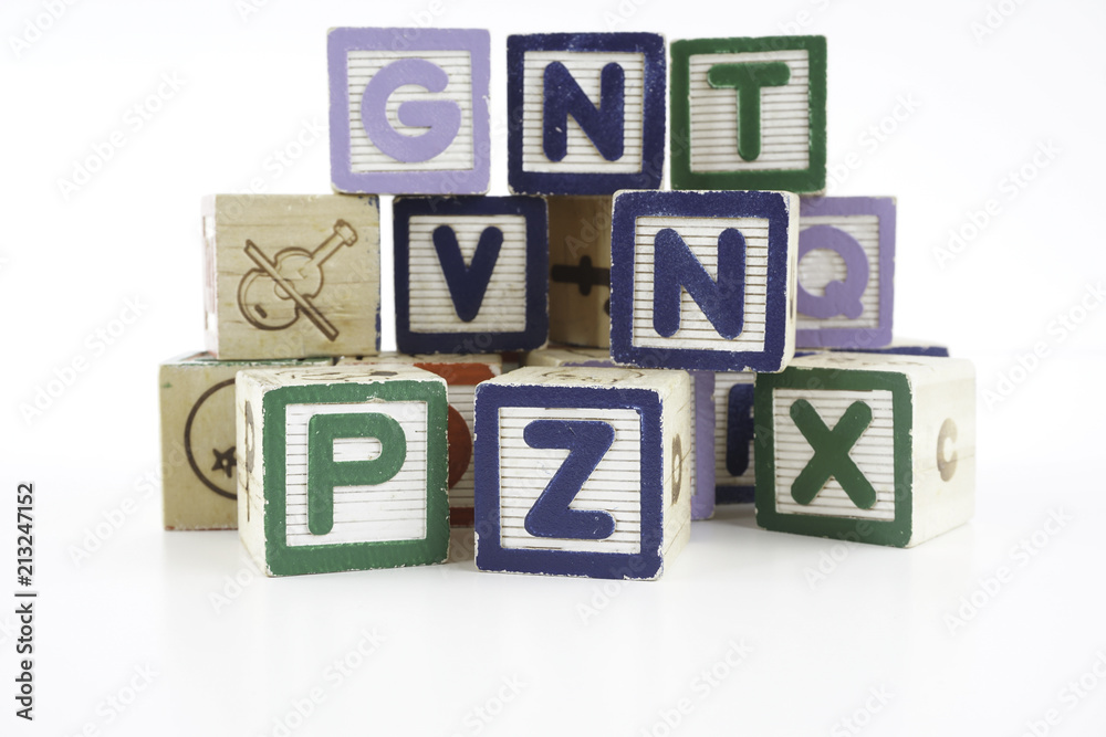 Colored wooden letter blocks on a white background with copy space Colored wooden letter blocks on a white background with copy space