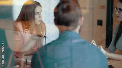 Diverse creative business team meeting in modern start up office young people group teamwork emotionally discussing project laugh and smile attractive european female team leader slow mo dolly shot