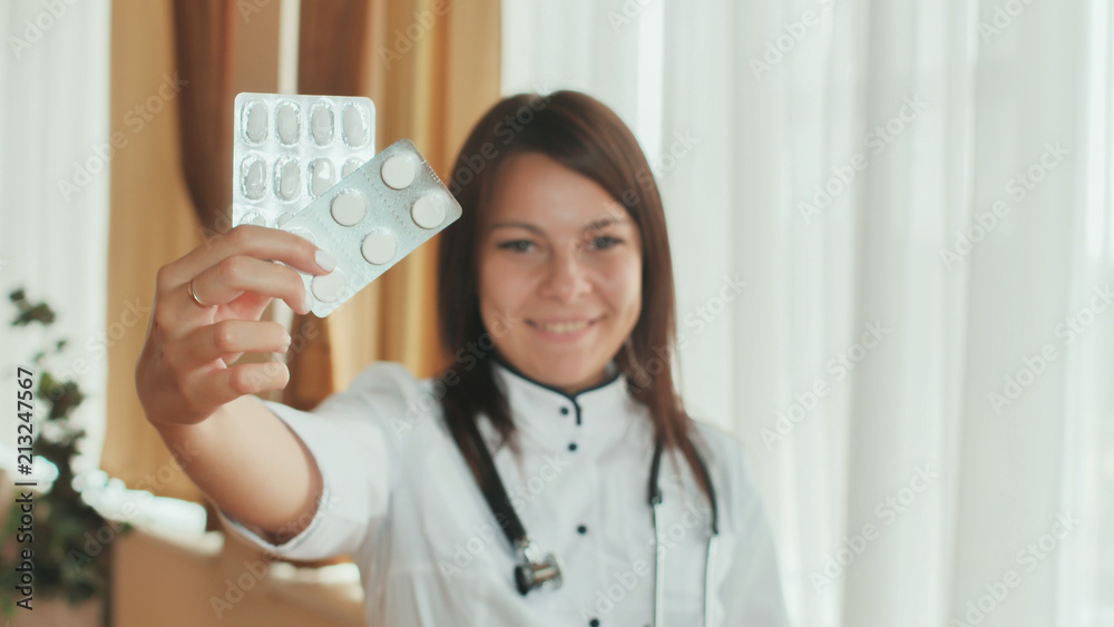 A young girl doctor demonstrates in the hands of a package of pills. A young girl doctor demonstrates in the hands of a package of pills.