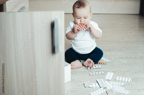 baby, girl sitting on the floor in the hands of pills photo