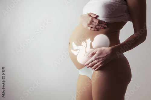 pregnant woman closeup of belly with visualisation of baby inside