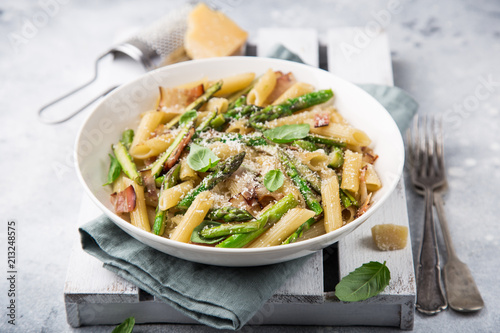 asparagus and bacon penne pasta with parmesan cheese in white bowl