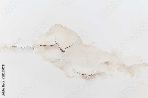 Big wet spots and cracks on the ceiling of the domestic house room after heavy rain and lot of water