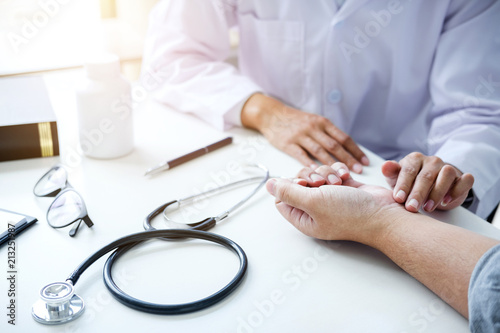 Doctor in white coat taking and checking the Patient's wrist pain during the examination