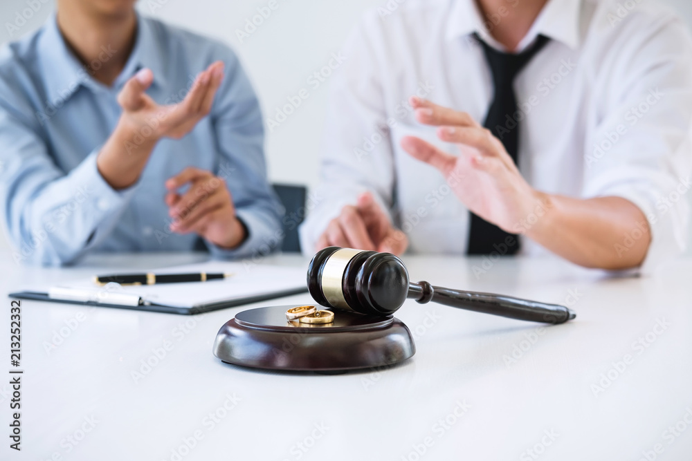 Contract decree of divorce (dissolution or cancellation) of marriage, husband and wife during divorce process and signing of divorce contract, Wedding ring Contract decree of divorce (dissolution or cancellation) of marriage, husband and wife during divorce process and signing of divorce contract, Wedding ring