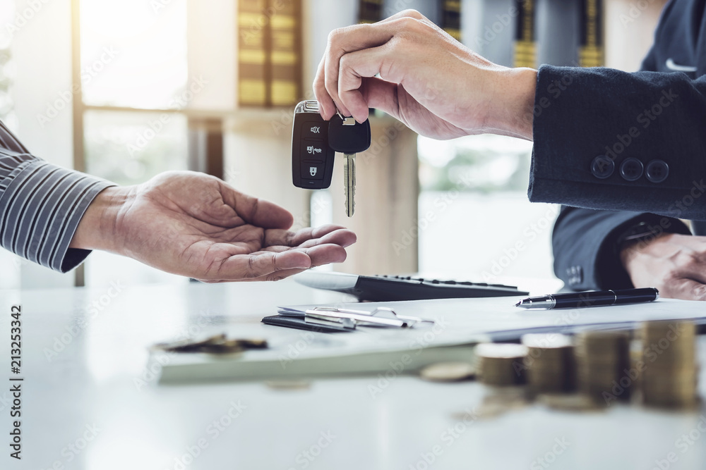 Salesman send key to customer after good deal agreement, successful car loan contract buying or selling new vehicle Salesman send key to customer after good deal agreement, successful car loan contract buying or selling new vehicle