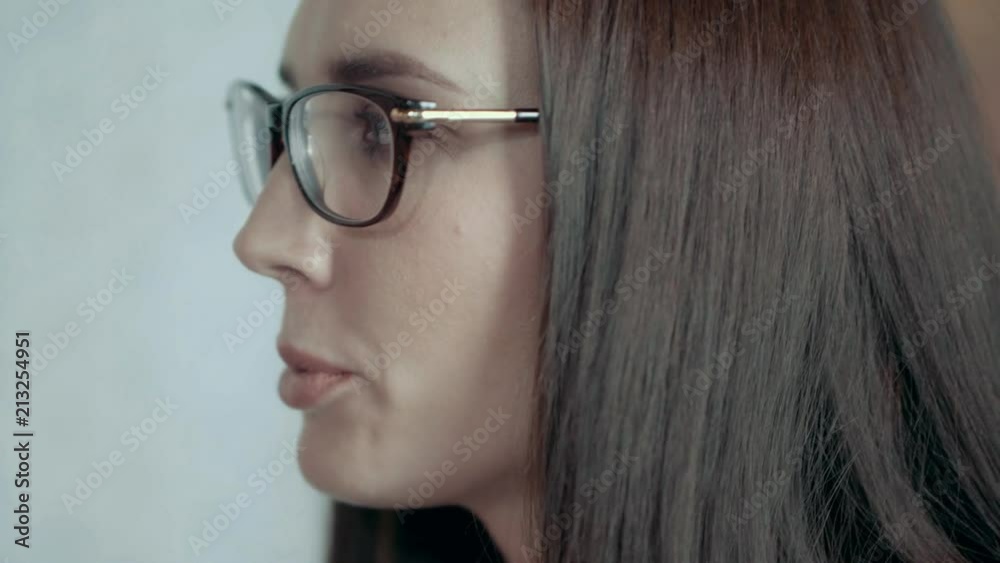 Closeup side view face of young european female team leader in glasses serious brunette woman emotionally speaks expresses dissatisfaction angry businesswoman at creative business team meeting tilt up Closeup side view face of young european female team leader in glasses serious brunette woman emotionally speaks expresses dissatisfaction angry businesswoman at creative business team meeting tilt up