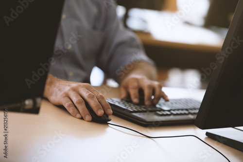 man"s hands typing away on computer
