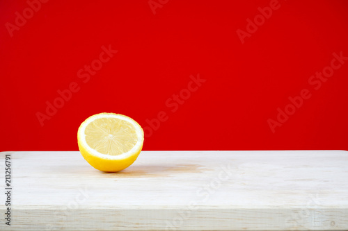 Lemon on a wooden table over red background
