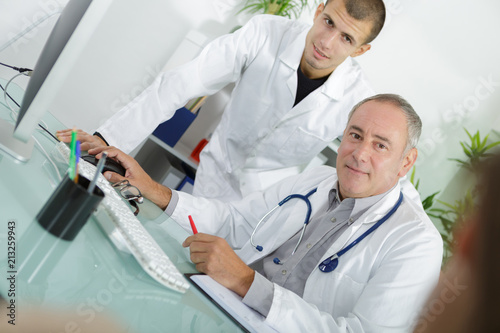 doctor talking to a patient with his young assistant