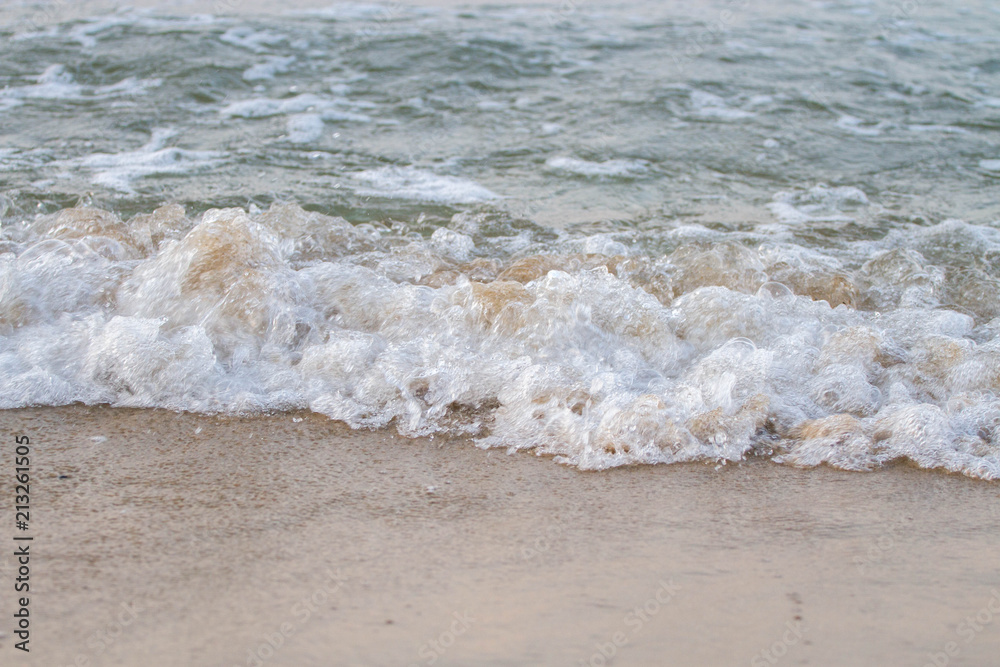 The sea waves on the beach in the morning, the sun is not soft focus