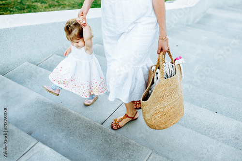 mom with a little daughter go up the stairs photo