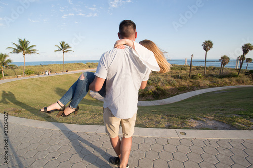 man lifting woman at park in summer location