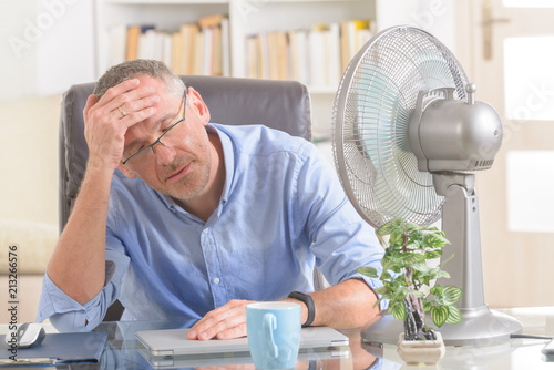 Man suffers from heat in the office or at home