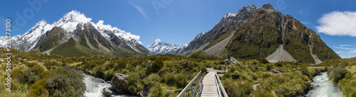 Panoramic view of Mount Cook and a hiking trail bridge over a river in Aoraki Mount Cook national park, south island, New Zealand